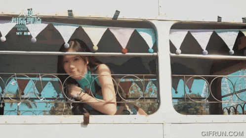 a woman leaning out of a window with a gifrun.com watermark