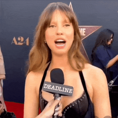 a woman is talking into a microphone with the word deadline on it