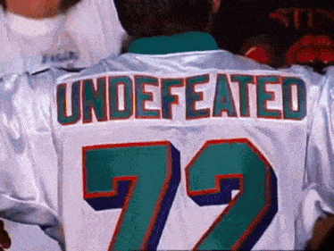 a man is wearing a white jersey with the number 72 on the back