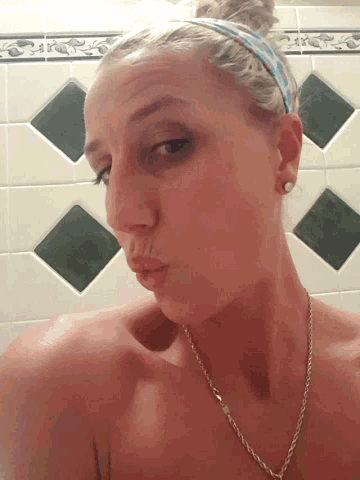 a woman wearing a headband and earrings is making a face