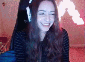 a woman wearing headphones is sitting in a chair and smiling .