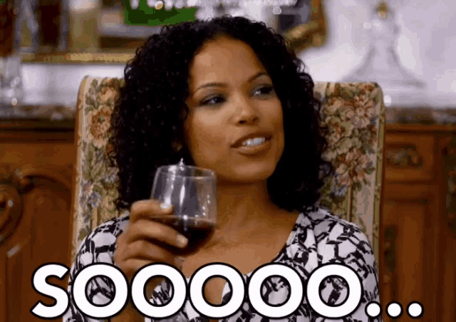 a woman is sitting in a chair holding a glass of wine and the word soooo is on the bottom