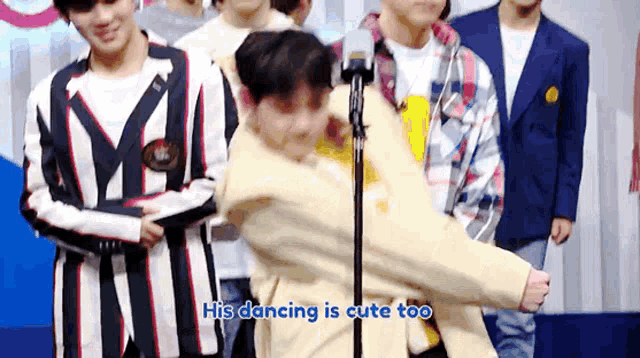 a boy is dancing in front of a microphone with the words " his dancing is cute too " written below him .