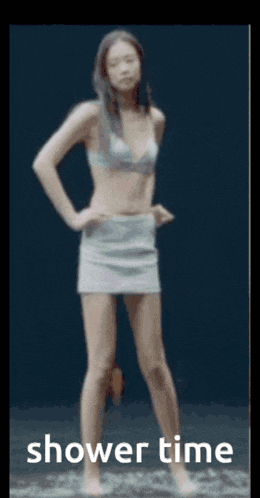 a woman in a bikini and skirt is standing in the water with the words shower time below her