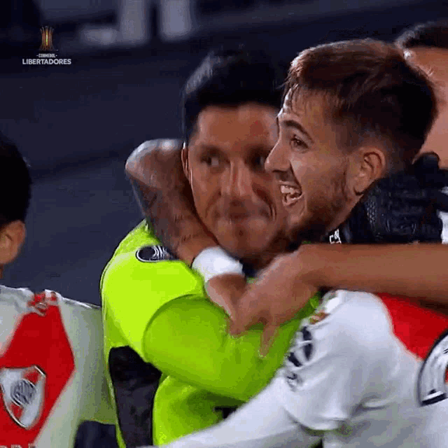 a group of soccer players are hugging each other with the word libertadores in the corner