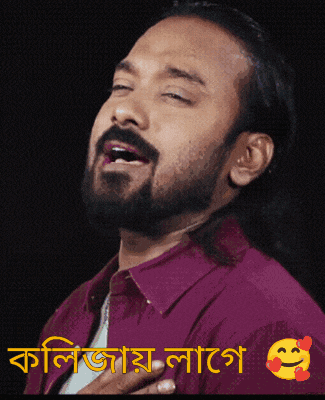 a man with a beard is wearing a purple shirt with a smiley face on the bottom right
