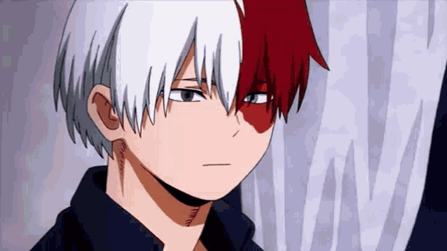 a close up of a person with red and white hair and a black shirt .