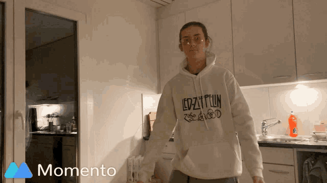 a woman wearing a white led zeppelin hoodie
