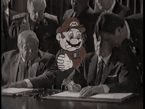a group of men are sitting at a table signing a document with a cartoon character standing next to them .