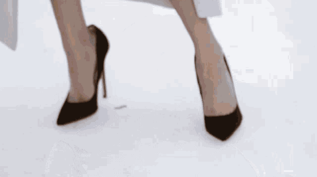 a woman is wearing a white jacket and a black dress .