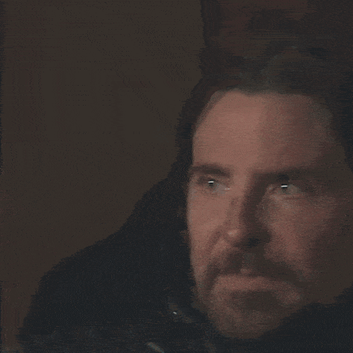 a close up of a man 's face with a beard and headphones on .
