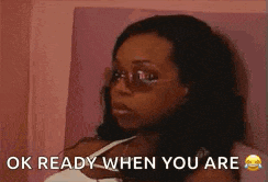 a woman wearing sunglasses and a white tank top is looking at the camera and says `` ok ready when you are '' .