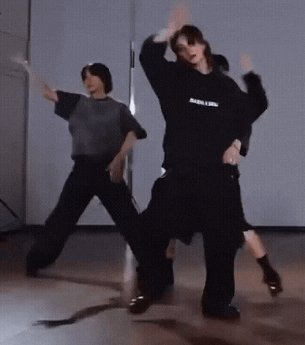 a group of people are dancing in a room with their arms in the air .