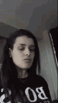 a woman is wearing a black shirt with the number 80 on it and making a funny face .
