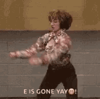 a man is dancing in front of a brick wall while wearing headphones .