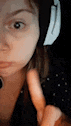 a close up of a woman 's face wearing headphones and making a funny face .
