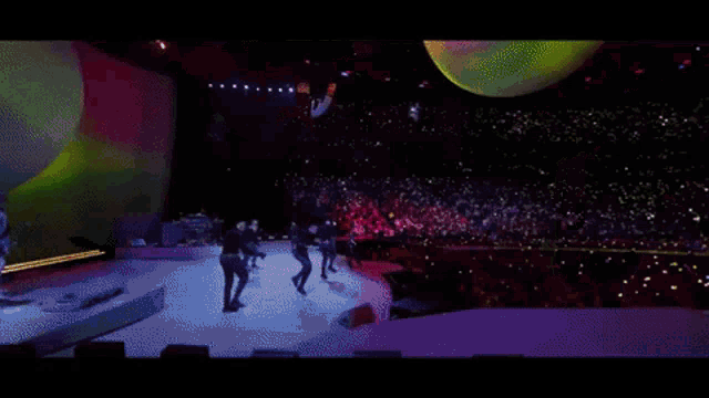 a crowd of people are watching a concert and one woman is holding a cell phone