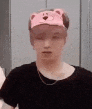 a man wearing a pink hat with a bear on it .