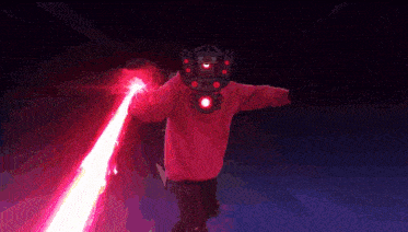 a person in a red robot costume is holding a beam of light
