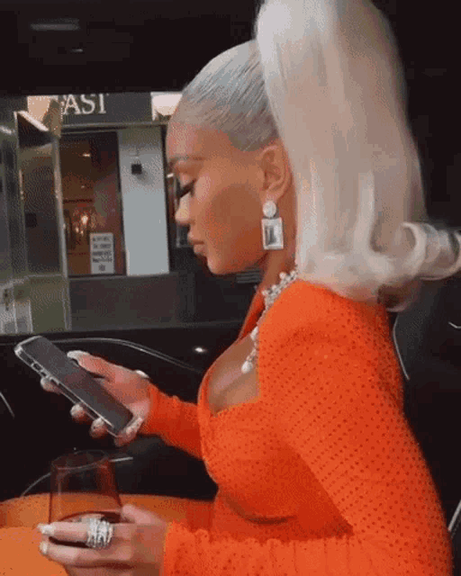 a woman sitting in a car looking at her phone