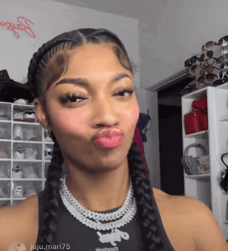 a woman wearing a braided hairstyle and a necklace that says reebok on it