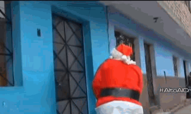 a man dressed as santa claus is walking down the street .