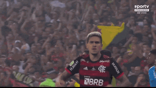 a soccer player is kneeling down on the field in front of a crowd of people .