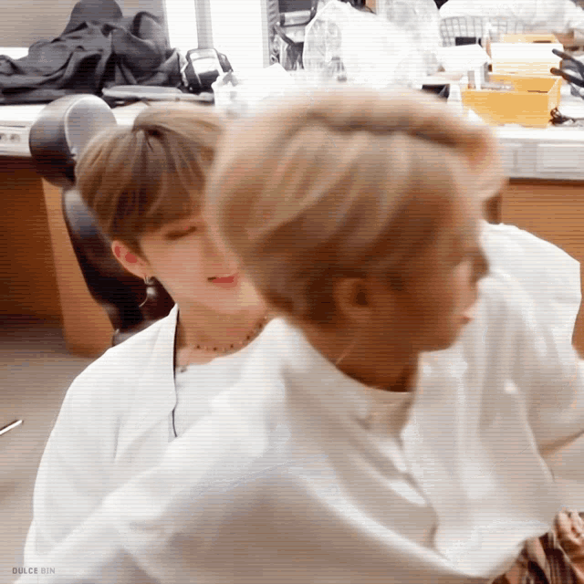 a couple of men are sitting next to each other in a room .