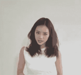 a woman in a white tank top is standing with her arms outstretched .