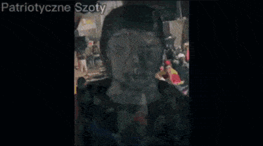 a crowd of people are gathered in a dark room and the words patriotyczne szoty are visible
