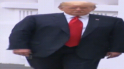 donald trump is wearing a suit and red tie and walking .