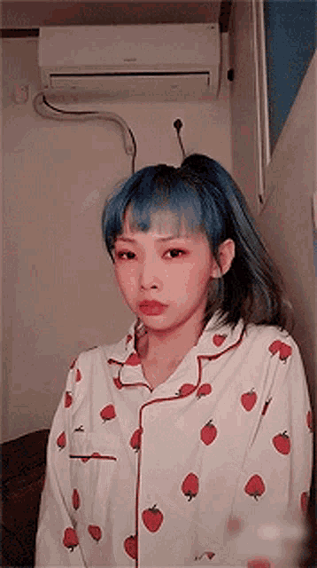 a girl with blue hair is wearing a strawberry pajama top