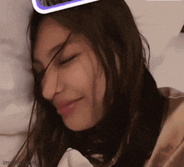 a woman laying in bed with her eyes closed and a sticker on her head