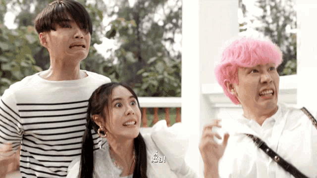 a man with pink hair is making a funny face next to a woman