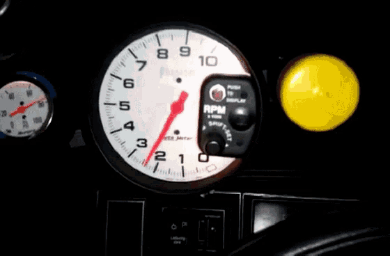 a white and red tachometer with the number 10 on the top