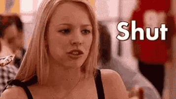 a woman is standing in front of a sign that says shut and holding a pizza .