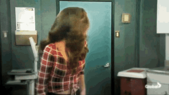a woman in a plaid shirt is standing in front of a door that says global on it