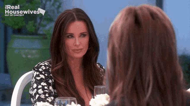 two women are sitting at a table with real housewives out of context written on the bottom