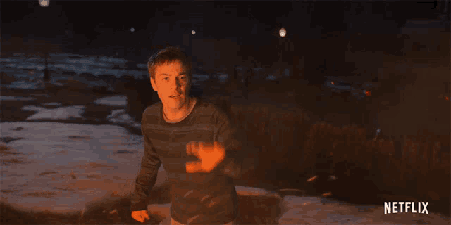 a man in a striped sweater is surrounded by flames and a netflix logo