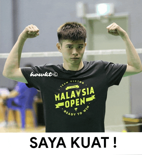 a man wearing a malaysia open t-shirt flexes his arms
