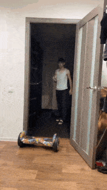 a man standing in a doorway with a hover board in front of him