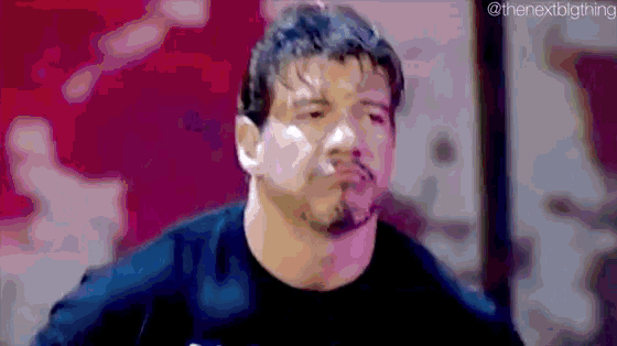 a man with a beard is wearing a black shirt and making a funny face .