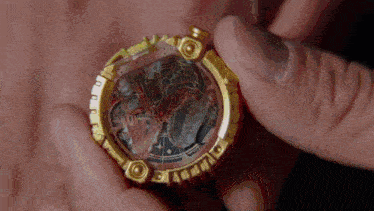 a person is holding a gold item in their hands .