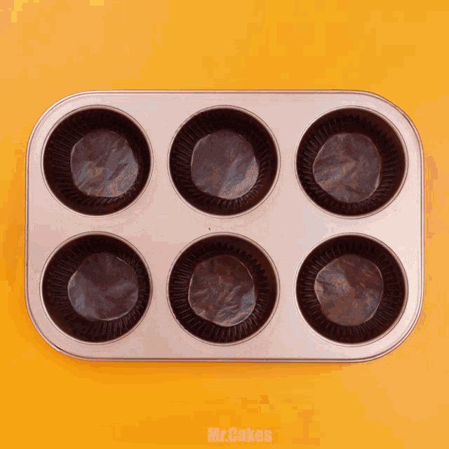 a person is using tongs to fill a muffin pan with cupcake liners