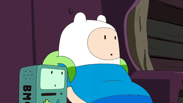 a cartoon character is sitting next to a bmo machine