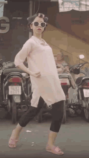 a woman in a pink dress and sunglasses has a license plate that says sl 02 8709
