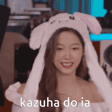 a woman wearing a white bunny hat with the words kazuha do ia written on it