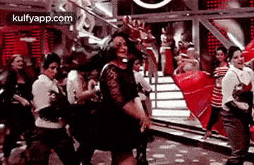 a woman is dancing in front of a crowd of people .
