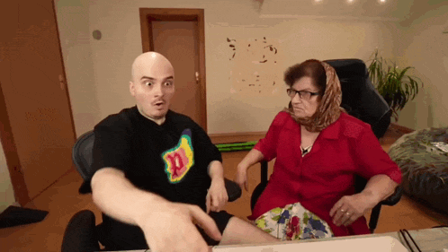 a man and a woman are sitting at a table and the woman is wearing a head scarf and glasses