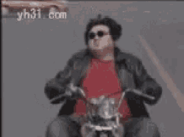 a man wearing sunglasses is riding a motorcycle with yh31.com in the background